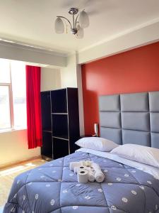 Un dormitorio con una cama azul con toallas. en Hotel Los Pajonales, en Huaraz