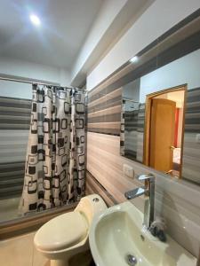 a bathroom with a toilet and a sink and a mirror at Hotel Los Pajonales in Huaraz