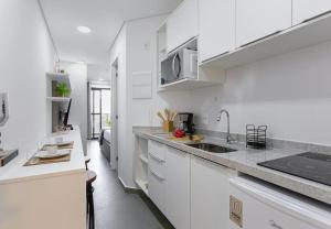 a white kitchen with white cabinets and a sink at Easy Star - Aconchego e Praticidade, próx ao Metrô - ET01H in Sao Paulo