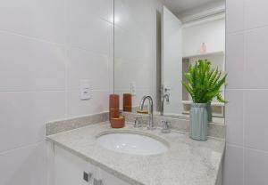 a bathroom with a sink and a vase with a plant at Easy Star - Aconchego e Praticidade, próx ao Metrô - ET01H in Sao Paulo