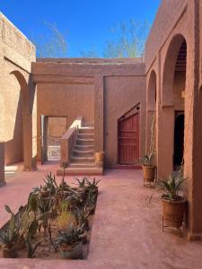 a courtyard of a building with a door and some plants at Casa Familia in Zagora