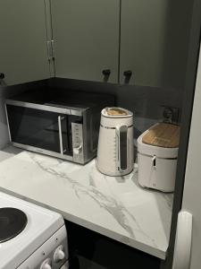 a kitchen counter with a microwave and a toaster at modern studio @ city center in Rovaniemi