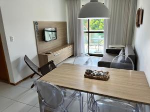 sala de estar con mesa con sillas y sofá en Iloa Residence 202, en Barra de São Miguel