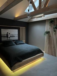 a bedroom with a bed with a black comforter at Clockhouse Cottage in Saulkrasti