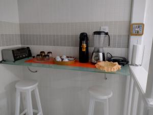 a kitchen counter with two stools and a blender at Fantástico in Santo Amaro
