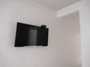 a flat screen tv on a white wall at Fantástico in Santo Amaro