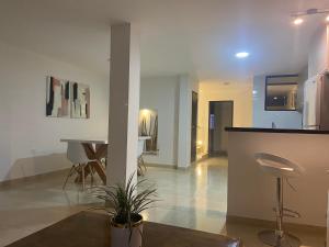 Una cocina y una sala de estar con mesa y sillas. en Casa San Sebastián, en San Gil