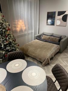 a living room with a christmas tree and two beds at modern studio @ city center in Rovaniemi