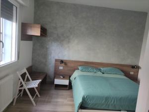 a bedroom with a bed and a chair and a window at SANT'AGOSTINO in Comacchio