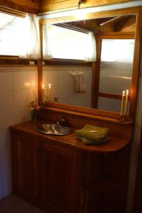 baño con lavabo, espejo y velas en Estancia La Esperanza en San Carlos de Bariloche