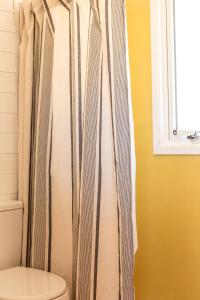 uma cortina de chuveiro na casa de banho com WC em Cabaña Agua de Mar em Punta Del Diablo