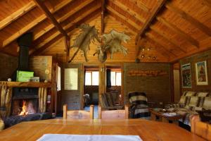 sala de estar con chimenea y techo de madera en Estancia La Esperanza en San Carlos de Bariloche