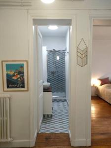 a bathroom with a walk in shower and a bedroom at Lumineux,chic, appartement Haussmannien de 50 m2 in Clichy