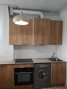 eine Küche mit einer Waschmaschine und einem Waschbecken in der Unterkunft Lumineux,chic, appartement Haussmannien de 50 m2 in Clichy