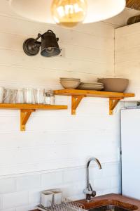 a kitchen with wooden shelves on the wall at Cabaña Agua de Mar in Punta Del Diablo