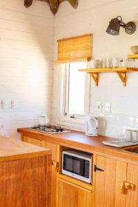 a kitchen with a microwave on a counter at Cabaña Agua de Mar in Punta Del Diablo