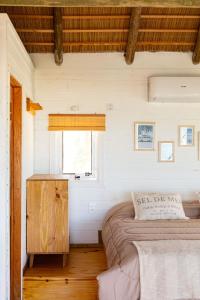 um quarto com 2 camas e uma janela em Cabaña Agua de Mar em Punta Del Diablo