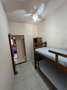 a bedroom with a bed and a ceiling fan at Casa Praia das Toninhas in Ubatuba