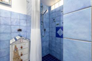 a blue tiled bathroom with a shower and a cabinet at Domo Anghèleda - Detached with large garden in a relaxing environment, a few minutes from the sea in Alghero