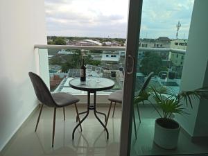 einen Balkon mit einem Tisch und Stühlen sowie einem Fenster in der Unterkunft Hermoso apartamento frente al mar in Ríohacha