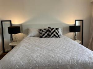 ein Schlafzimmer mit einem weißen Bett mit zwei Lampen in der Unterkunft Casa Blanca Beach in Ciudad de la Costa