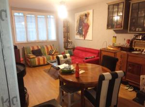 a living room with a table and a red couch at Chambre avec balcon - Parc des Expos Porte de Versailles in Vanves