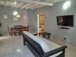 een woonkamer met een bed en een eetkamer bij En Familia in Puerto Iguazú