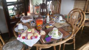a wooden table with plates of food on it at Chales Joia Rara Dos Gnomos in Visconde De Maua +16 photos