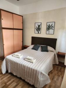 ein Schlafzimmer mit einem großen weißen Bett mit zwei Kissen in der Unterkunft -CASA YERBAL- 4 amb - Reserva mínima 2 noches DIR YERBAL 1125 in Buenos Aires