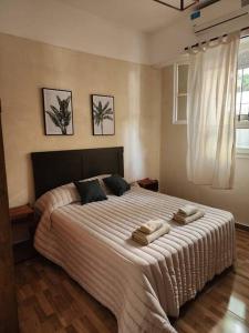 ein Schlafzimmer mit einem großen Bett mit zwei Handtüchern darauf in der Unterkunft -CASA YERBAL- 4 amb - Reserva mínima 2 noches DIR YERBAL 1125 in Buenos Aires