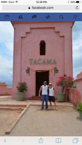 two people standing in front of a pink building at Ica adventures out of the woods in Ica