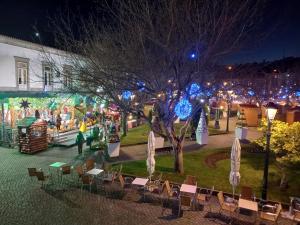 un marché de Noël dans un parc aux lumières de Noël dans l'établissement Garden House Fundão - Estúdio 102 com vista jardim, à Fundão