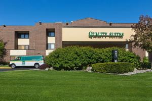 Un edificio con una camioneta estacionada enfrente. en Quality Suites Lansing West, en Lansing