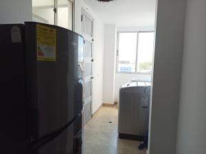um frigorífico preto num quarto com uma janela em Hermoso apartamento frente al mar em Ríohacha