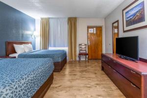 a hotel room with two beds and a flat screen tv at Econo Lodge Inn & Suites on the River in Gatlinburg