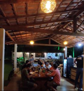 um grupo de pessoas sentadas numa mesa num restaurante em Pousada Jardim de Pedras em Pancas
