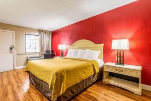 Habitación de hotel con cama con pared roja en Econo Lodge, en Berea