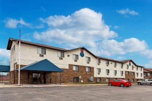 a building with a red car parked in a parking lot at Econo Lodge Inn & Suites in Auburn