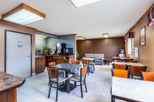 a restaurant with tables and chairs and a kitchen at Econo Lodge Inn & Suites in Auburn