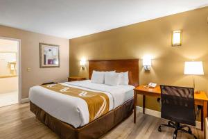 ein Hotelzimmer mit einem großen Bett und einem Schreibtisch in der Unterkunft Quality Inn Quincy - Tallahassee West in Quincy