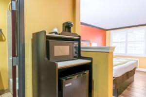 a room with a refrigerator with a television on it at Quality Inn & Suites in Sacramento