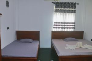 dos camas sentadas una al lado de la otra en una habitación en Dinuli home stay, en Ahungalla