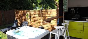 a backyard with a tub and chairs and a fence at Rêve créole "villa Lina" Mer Plage Spa in Deshaies