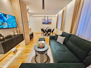 ein Wohnzimmer mit einer grünen Couch und einem Tisch in der Unterkunft Dream Luxury Jahorina in Jahorina