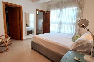 ein Schlafzimmer mit einem Bett mit einer Lampe und einem Spiegel in der Unterkunft Goistay Un Refugio Bohemio Chic in Santo Domingo