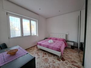 1 dormitorio con 1 cama rosa y 2 ventanas en B&B Al Centro, en Presicce