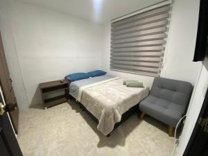1 dormitorio pequeño con 1 cama y 1 silla en Apartamento en la Toscana, en Manizales