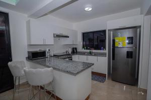 eine Küche mit einer Theke und einem Kühlschrank in der Unterkunft villa green paradise in San Felipe de Puerto Plata