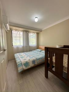 WoollamiaにあるAt holiday houseの小さなベッドルーム(ベッド1台、窓付)