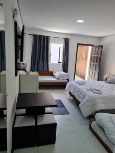 Habitación de hotel con 2 camas y mesa en Estalagem Floradas da Serra, en São Joaquim